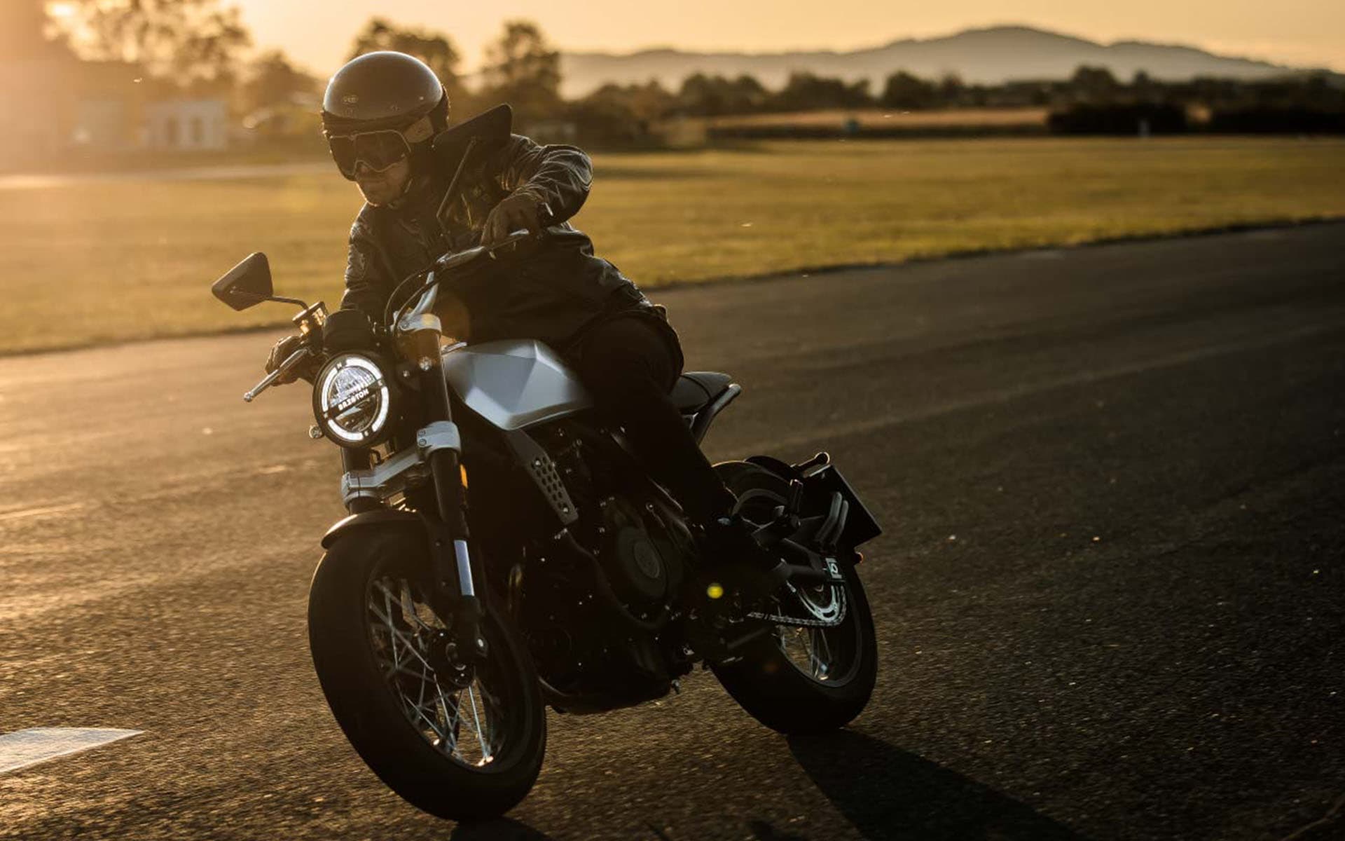 Rider driving a Brixton Crossfire 500 in Bullet Silver at sunset